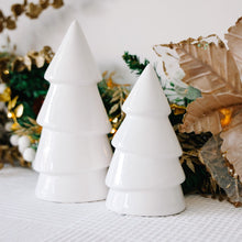 Load image into Gallery viewer, Two white ceramic Christmas tree ornaments on a textured surface with decorative background.