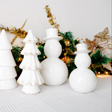 Load image into Gallery viewer, White ceramic Christmas trees and snowmen with gold accents against a festive background.