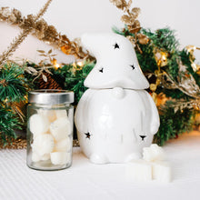 Load image into Gallery viewer, White Christmas Gonk-shaped wax melt burner with a jar of white wax melts against a festive background with greenery and lights.

