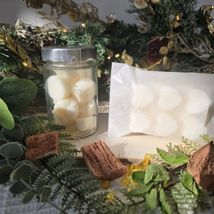 Jar & bar of wax melts with a festive decorative background featuring greenery and lights.