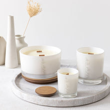 Load image into Gallery viewer, A picture of 3 different sized candles, showing the difference between small, medium and large candles. All of which have wooden wicks and are in white glass vessels with the MJM Home Fragrance logo
